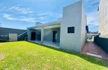 Atrs da casa com um gramado verde